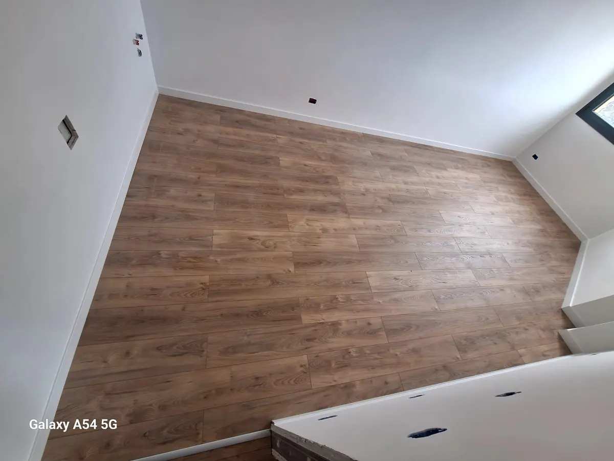 Pavimento in legno posato in una mansarda con finestra da tetto
