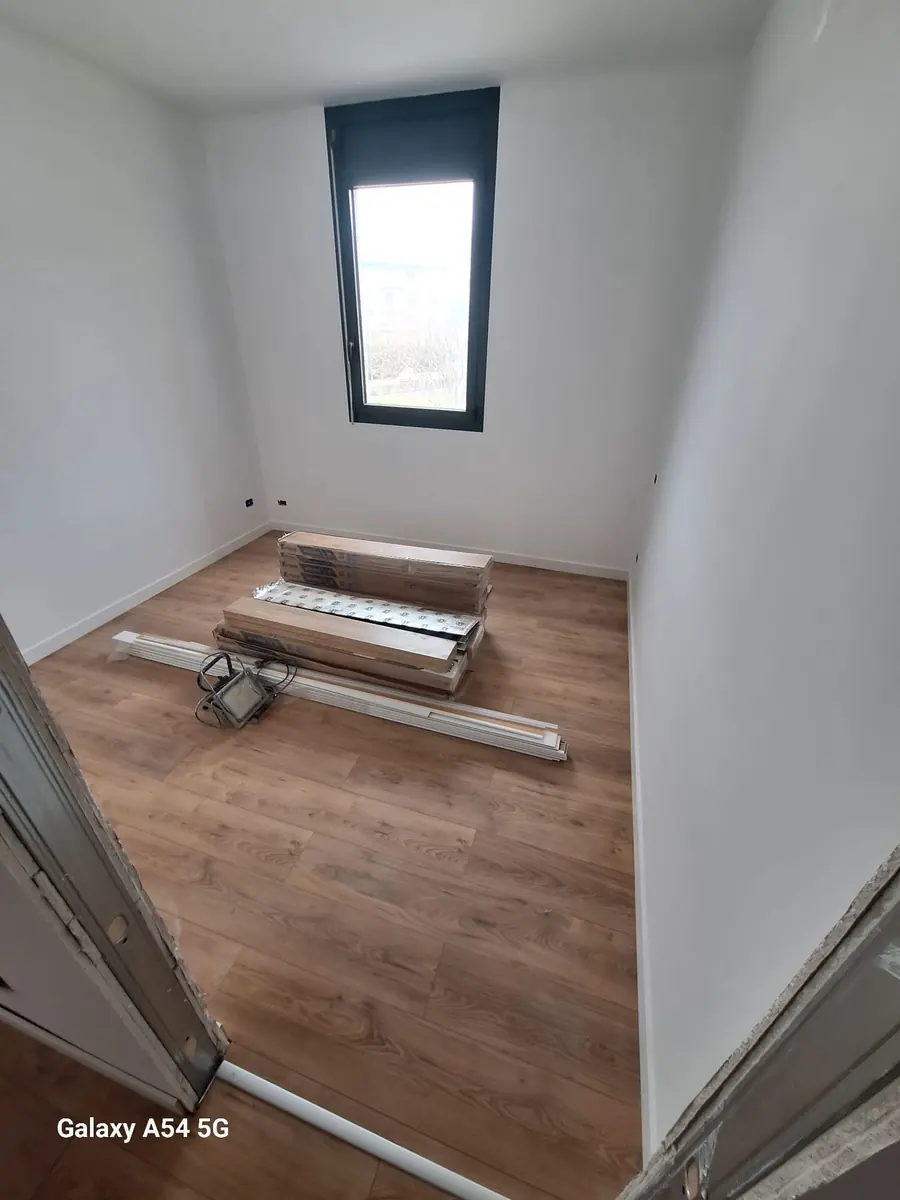 Stanza con il pavimento posato e i materiali per i battiscopa
